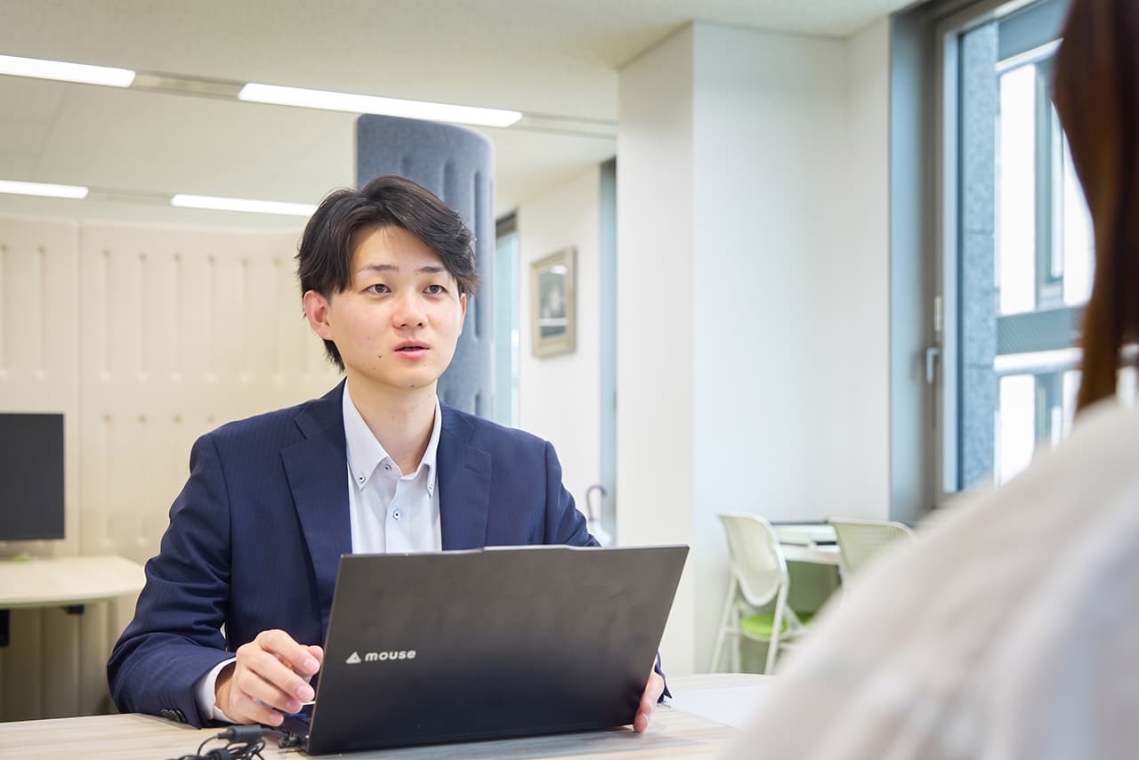 イメージ：同僚と言葉をかわすYさん